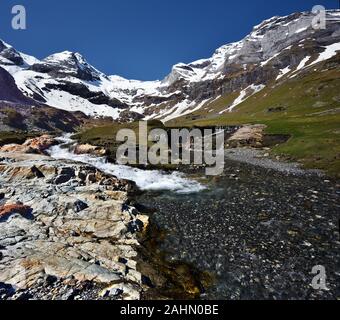 Vue panoramique de boucher plateau en Pyrénées françaises au printemps, avec d'eau au premier plan et Maillet montagnes enneigées du Cirque de Troumouse et Port d Banque D'Images