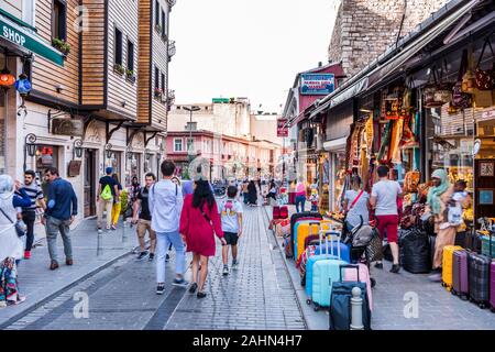 Les touristes à pied dans la rue à côté Européen avec des souvenirs et une boutique de souvenirs et de cafés sur une journée d'été occupée d'Istanbul, Turquie Banque D'Images