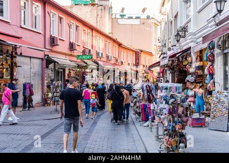 Les touristes à pied dans la rue à côté Européen avec des souvenirs et une boutique de souvenirs et de cafés sur une journée d'été occupée d'Istanbul, Turquie Banque D'Images