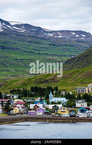 Seythisfjorthur port et sur la ville dans l'Est de l'Islande entouré de montagnes, l'eau du Fjord est au premier plan Banque D'Images