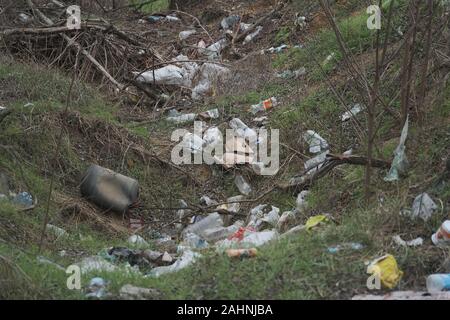 Déchets en plastique dump élémentaire sur le bord de la route près de la périphérie de la forêt. La pollution de l'environnement avec du plastique et autres déchets. Banque D'Images