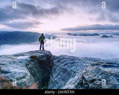 Les hommes sur la montagne de profiter vue aérienne avec bras levés au-dessus des nuages de Vie Voyage aventure concept Réussite Banque D'Images