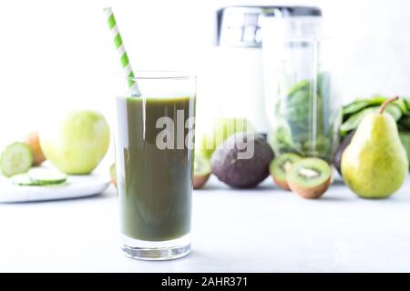 Un grand verre de smoothie vert vert avec des fruits et des légumes et le blender dans derrière. Notion de perte de poids. Banque D'Images