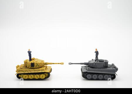 2 personnes miniature businessmen standing sur Toy réservoir. La négociation en affaires. comme arrière-plan de guerre commerciale, la protection du commerce, guerre politique, les affaires d'hiver Banque D'Images