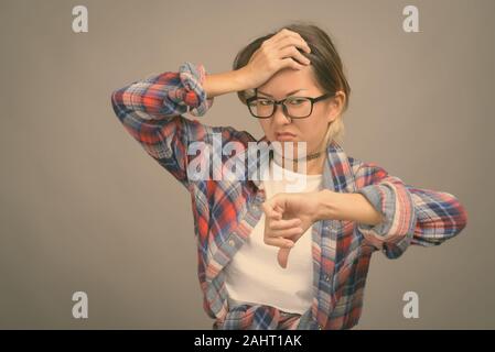 Studio shot of young woman wearing Kazakh belle chemise à carreaux contre l'arrière-plan gris Banque D'Images