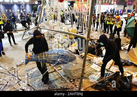 Hong Kong, Chine. 31 Dec, 2019. Des milliers de manifestants anti-gouvernementaux de prendre la rue et de protestation dans plusieurs centres commerciaux sur le jour de l'an. Ici érigent des barrages routiers pour occuper Nathan Road en utilisant les décorations de Noël. Gonzales : Crédit Photo/Alamy Live News Banque D'Images