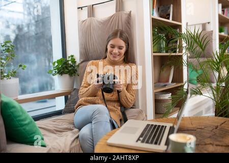 L'édition photographe souriant ses images dans photoshop Banque D'Images