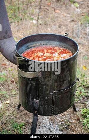 Délices électrique goulash avec rencontrez, le poivre, les tomates, l'oignon dans un grand chaudron à l'extérieur Banque D'Images