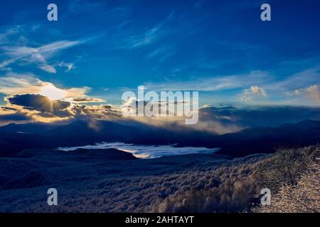 Lever du soleil par derrière une chaîne de montagnes. Les silhouettes des montagnes contre le ciel. Panorama de la montagne au lever du soleil. Banque D'Images