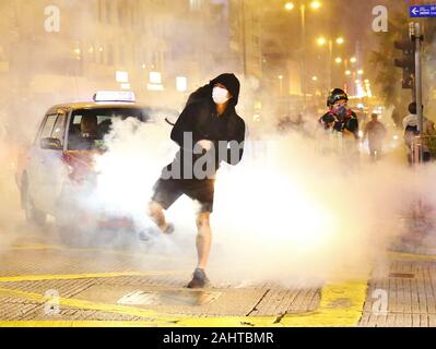 Hong Kong, Chine. 25, décembre 2019. Noël à Hong Kong est marquée par des manifestations et désobéissance civile. Ici la police anti-émeutes déployer des gaz lacrymogènes à Tsim Sha Tsui, manifestants et les civils s'enfuient. Banque D'Images