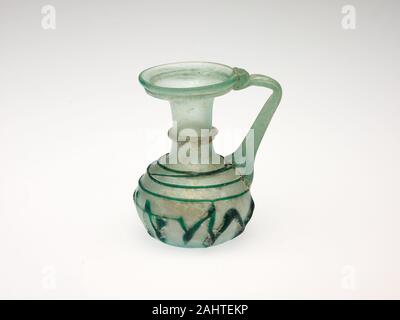 Ancienne cité romaine. Verseuse. 301-400 AD AD. Levant. La technique du verre soufflé, des récipients en verre ont fait partie de la luxueuse décoration intérieure affichée dans les ménages riches villas dans les zones urbaines et rurales dans les successions et Romain début byzantine (environ 300-725), et ont été utilisés à des fins diverses, y compris les contenants cosmétiques, cruches d'eau ou de vin, et petite tasse pour boire. Artisans verre byzantin amélioré les techniques, les formes, et de motifs décoratifs qu'ils avaient hérité de leurs prédécesseurs romains. Un édit impérial de 337 verriers exemptés de l'impôt personnel et atteste Banque D'Images