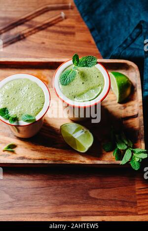 Deux portions de green smoothie aux épinards avec des bananiers, de la chaux et du lait d'avoine. Banque D'Images