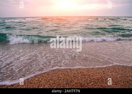 Soirée avec une vague de la mer se précipiter sur la rive. Banque D'Images