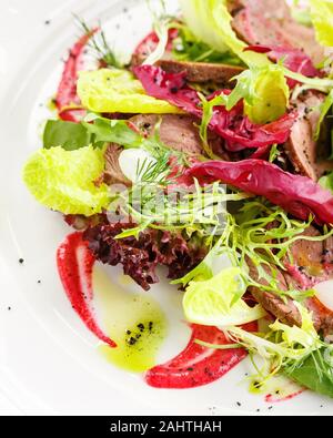 Mélanger avec la salade verte rôti de bœuf et sauce aigre-douce. Restaurant le plat. Close-up Banque D'Images