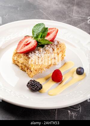 Napoléon traditionnel gâteau feuilleté à la crème vanille et fruits rouges, garnie de fraises et de la menthe dans un restaurant. La cuisine russe, layere Banque D'Images