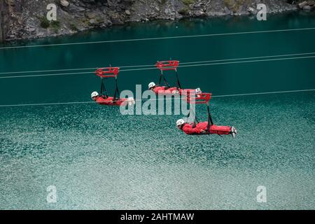 Trois personnes sur le Velocirty 2 lignes zip Zip à Penrhyn Quarry mondiale, au nord du Pays de Galles, Royaume-Uni Banque D'Images