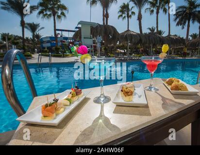 Deux cocktails et canapés sur table au tropical hotel de luxe resort prix par piscine Banque D'Images