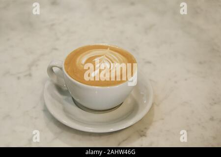 Une tasse de délicieux cappuccino sur une table en marbre. Banque D'Images