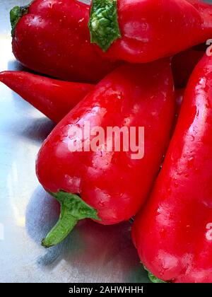 Poivrons rouge bio sont regroupés sur un comptoir de l'aluminium dans une cuisine à Alicante, Espagne, Europe Banque D'Images