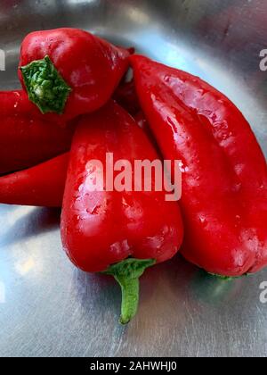 Poivrons rouge bio sont regroupés sur un comptoir de l'aluminium dans une cuisine à Alicante, Espagne, Europe Banque D'Images