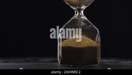 Le sable se déplace dans Hourglass. Close up de l'heure horloge en verre. Old Time Timer sablier classique. Libre de sable est de tomber et mesurer le temps Banque D'Images