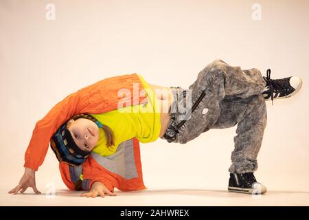 Jeune fille dans une position de danse unique, breakdance kid, une petite fille, un enfant breakdance effectue dans une danse acrobatique unique poser Banque D'Images