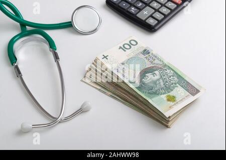 Pile de billets d'origine polonaise, stéthoscope et calculateur sur le tableau blanc. Services médicaux concept financier Banque D'Images