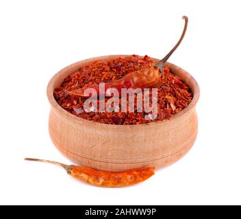 Sec et flocons de piment broyé isolé sur fond blanc. Red chili pepper dans le bol en bois. Banque D'Images
