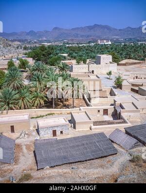 Le rénové, abandonnées ruines de Hatta Fort et village en Province de Dubaï aux Émirats arabes unis à la recherche vers la ville et les plantations de palmeraies oasis verte Banque D'Images