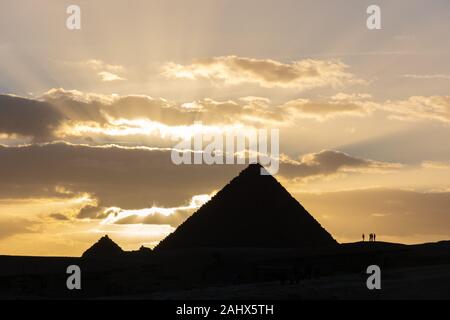 Silhouette de pyramide de Menkaourê et plusieurs personnes en face de coucher du soleil à Gizeh pyramide complexe. Banque D'Images