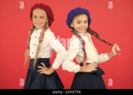 Sur la même vague. Usure uniforme de l'école formelle écolières. Les enfants belles filles de long cheveux tressés. Peu de filles avec des tresses, des prêts pour l'école. Concept de la mode de l'école. Style de fantaisie. L'École de l'amitié. Banque D'Images