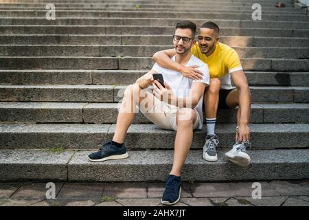 Portrait of happy couple gay, passer du temps ensemble et de prendre un téléphone mobile avec selfies. Amour Lgbt et concept. Banque D'Images