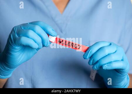 Infirmière de l'hôpital Alerte allergie bande ID avant de la placer sur le poignet du patient. Banque D'Images