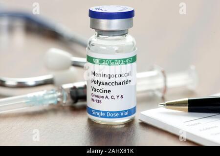 Polysaccharidique contre le méningocoque flacon sur l'physcian 24 avec seringue, stéthoscope et stylo. Banque D'Images