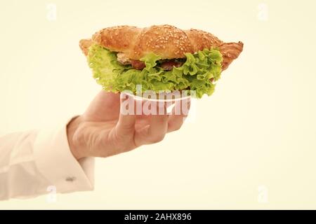 Les Calories et les régimes amaigrissants. Servant un croissant farci de laitues et légumes frais. Cafe concept. Alimentation saine. Croissant traditionnel français. Main de garçon porter la plaque avec le plat. De délicieux croissants. Banque D'Images