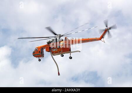 La lutte contre l'incendie Erickson Air Crane hélicoptère S-64 N243AC décoller après le remplissage avec une charge d'eau d'un petit lac avant de tomber sur un Banque D'Images