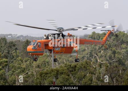 Erickson Air Crane hélicoptère décoller après le remplissage avec une charge d'eau pour combattre un incendie. Banque D'Images