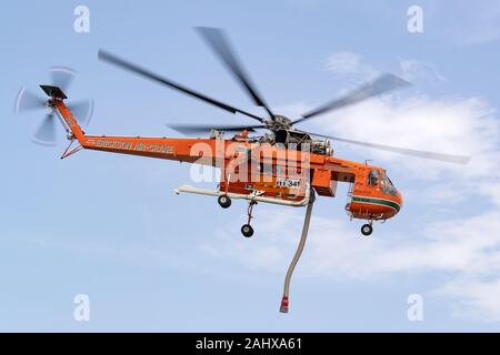 La lutte contre l'incendie Erickson Air Crane hélicoptère S-64 N243AC décoller après le remplissage avec une charge d'eau d'un petit lac avant de tomber sur un Banque D'Images