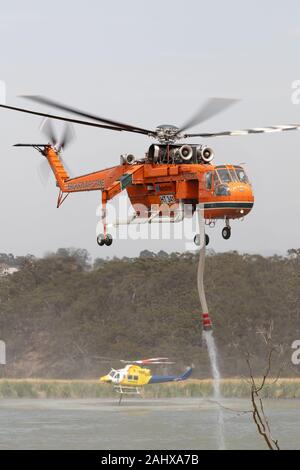 Erickson Air Crane hélicoptère décoller après le remplissage avec une charge d'eau pour combattre un incendie. Banque D'Images