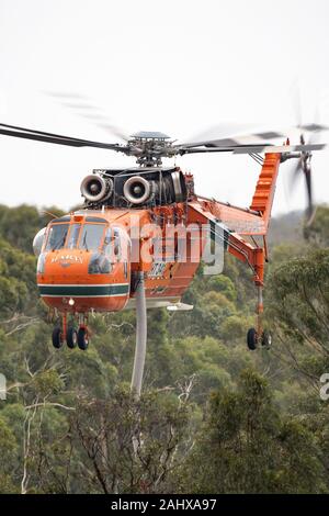 Erickson Air Crane hélicoptère décoller après le remplissage avec une charge d'eau pour combattre un incendie. Banque D'Images