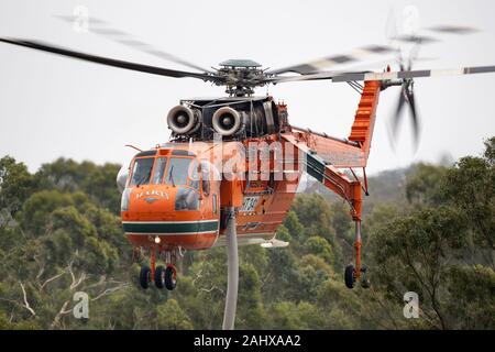 Erickson Air Crane hélicoptère décoller après le remplissage avec une charge d'eau pour combattre un incendie. Banque D'Images