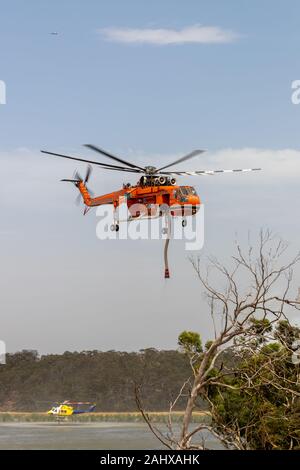 Erickson Air Crane hélicoptère décoller après le remplissage avec une charge d'eau pour combattre un incendie. Banque D'Images