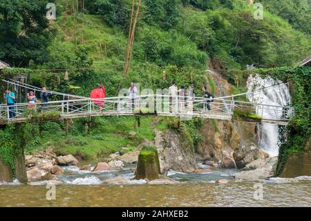 Cat Cat, le Vietnam - 20 août 2017 : les touristes sur le pont avec belle cascade sur l'arrière-plan Banque D'Images