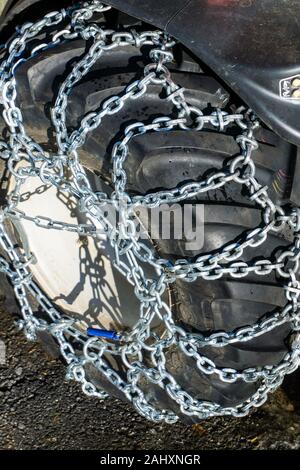Une vue rapprochée des chaînes à neige sur la montagne de pneus petit tracteur en hiver Banque D'Images