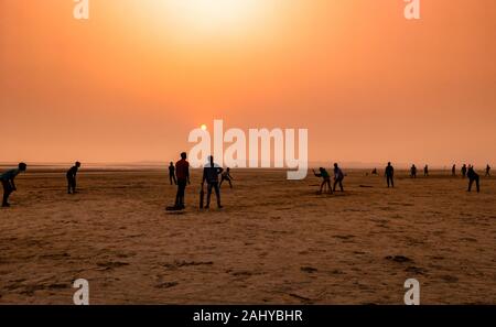 Silhouette de personnes , jouer au cricket au moment de coucher de soleil sur une plage. Banque D'Images