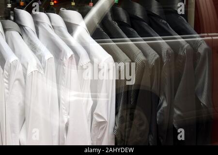 Chemises noires et blanches sur des cintres tourné à travers une vitrine. Style et luxe tenues. Banque D'Images