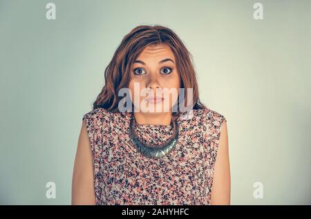 Femme confuse. Malheureux en colère closeup portrait jeune personne en haussant les épaules, je ne sais pas isolés concept Green wall background. E négative de l'humain Banque D'Images
