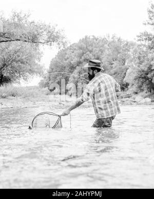 Guide de pêche et passe-temps. Les activités sportives. pothunter. week-end d'été. Pêche au gros barbu. dans l'eau. fisher pêcheur avec canne à pêche. mature man fly fishing. man la capture de poissons. Banque D'Images