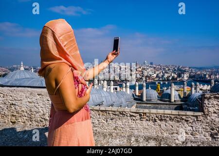 Une femme prend un à selfies Süleymaniye Camii, la Mosquée Süleymaniye, le quartier Karaköy avec la tour de Galata, Galata Kulesi, dans la distance Banque D'Images