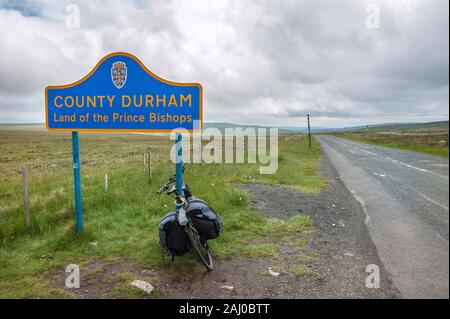 Comté DE DURHAM, ANGLETERRE - 15 JUIN 2016 - UN vélo de randonnée penchant contre un panneau à la frontière du comté de Durham, dans le nord de l'Angleterre Banque D'Images